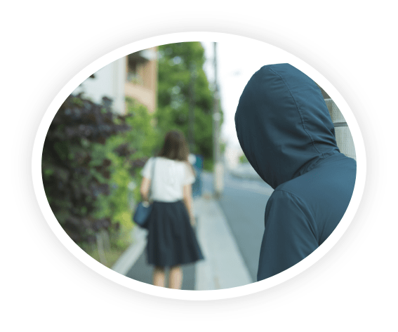 女性を背後から見つめる不審者